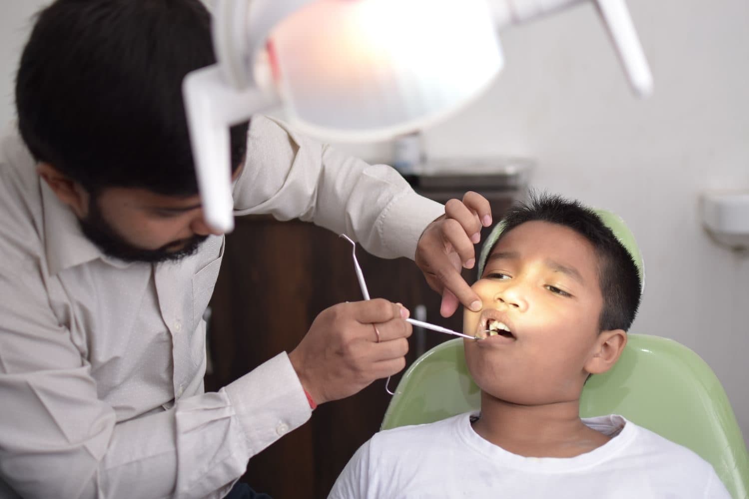 A dentist gently examining a child